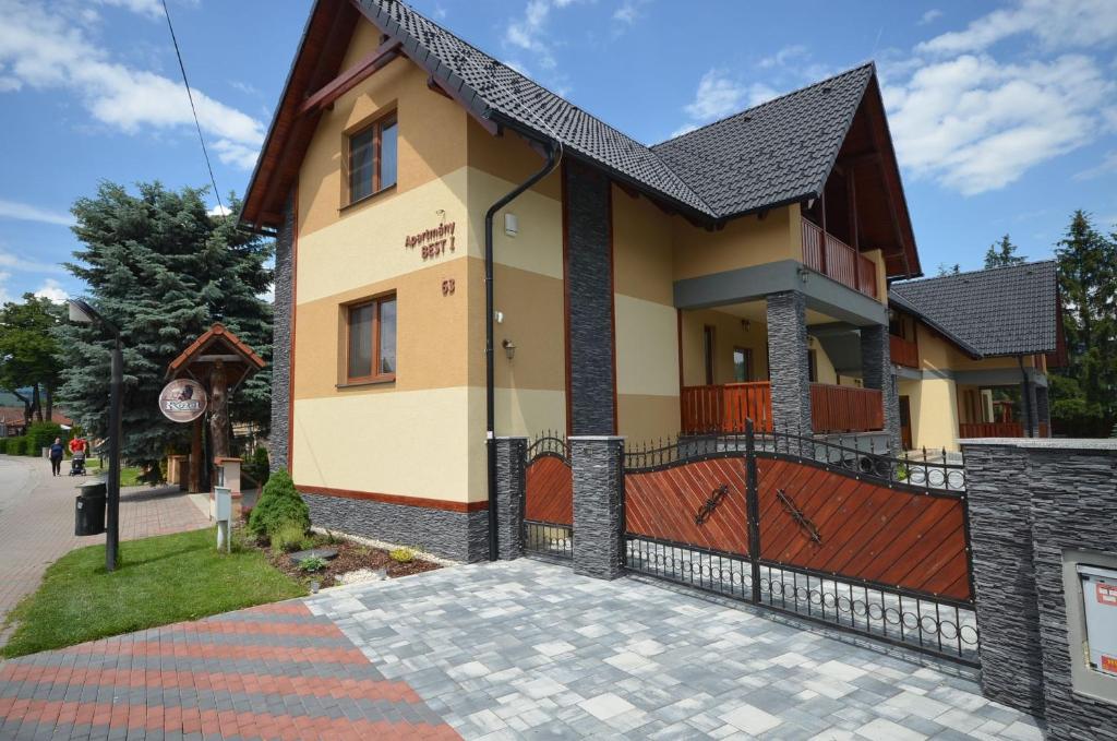 uma casa com um portão e uma entrada em Apartmány Best I. Bešeňová em Bešeňová