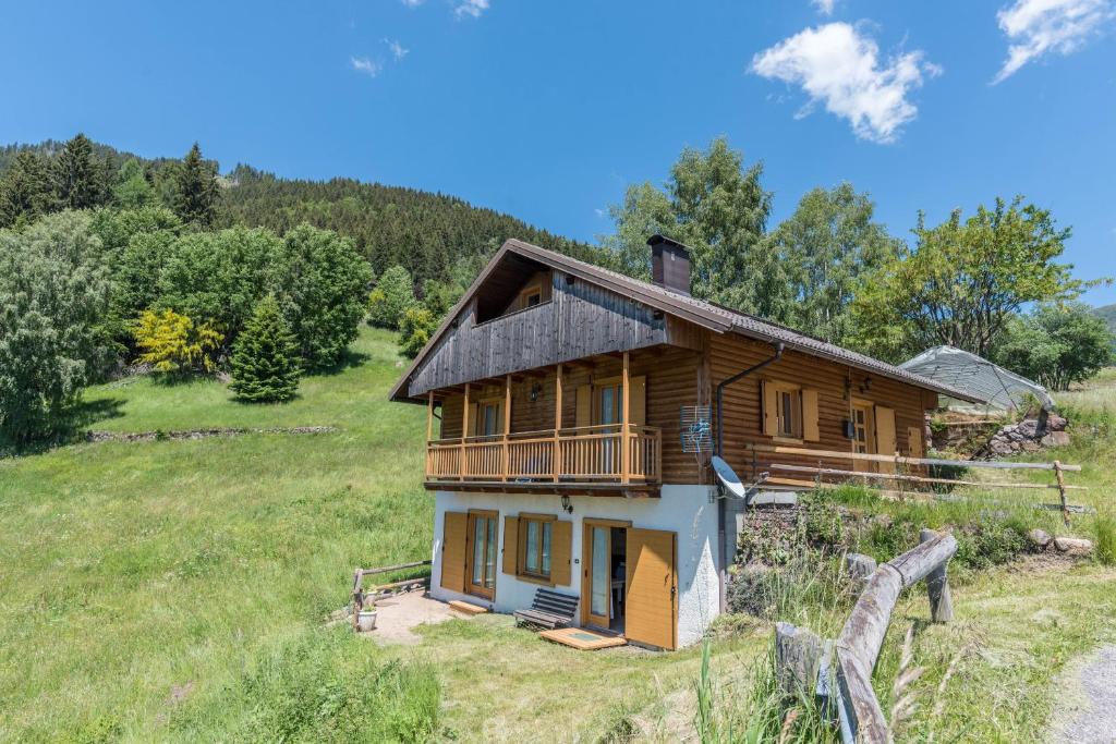 une maison en rondins sur une colline dans un champ dans l'établissement Baita Serpillo, à Palù del Fersina