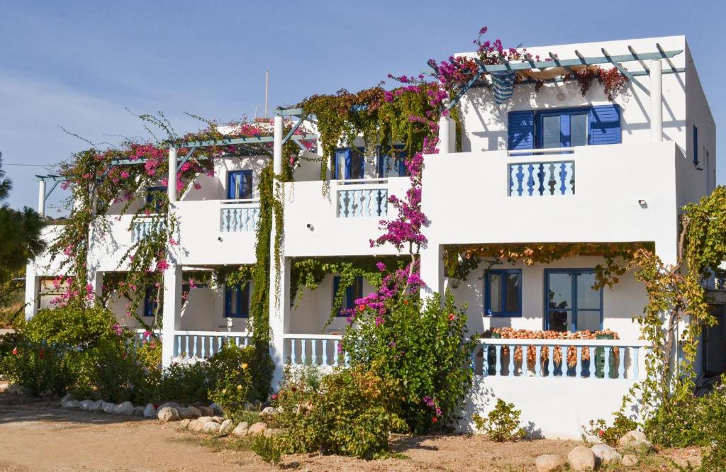 un edificio blanco con flores en los balcones en Akrogiali Apartments, en Lefkos Karpathou