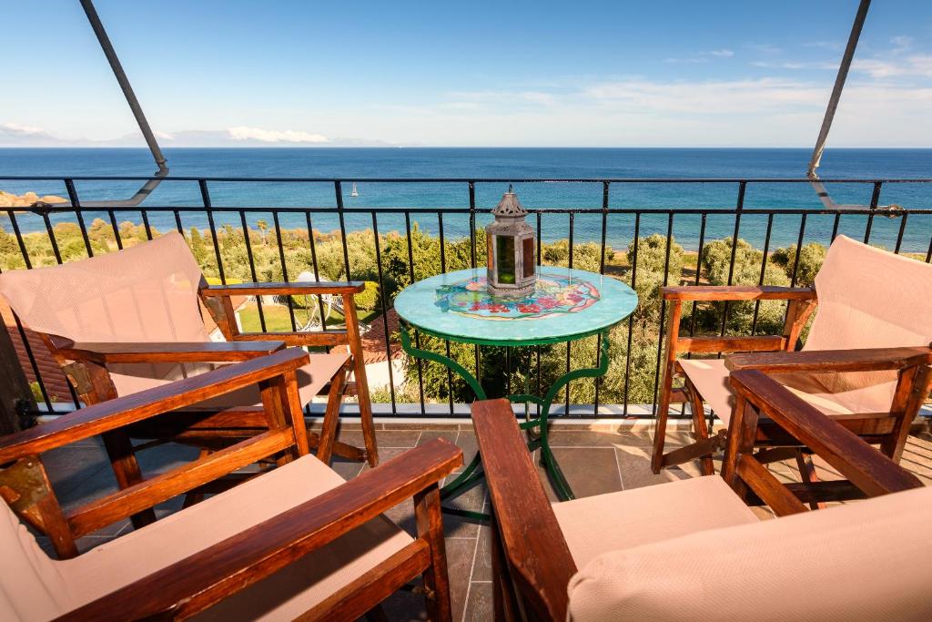 uma varanda com cadeiras e uma mesa com vista para o oceano em Eros Pittoresque Retreats - Perfect location, Panoramic Seaview em Koroni