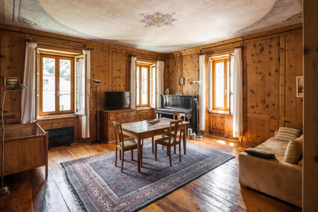 a living room with a table and a couch at In val Bregaglia mille possibilità di benessere in Castasegna