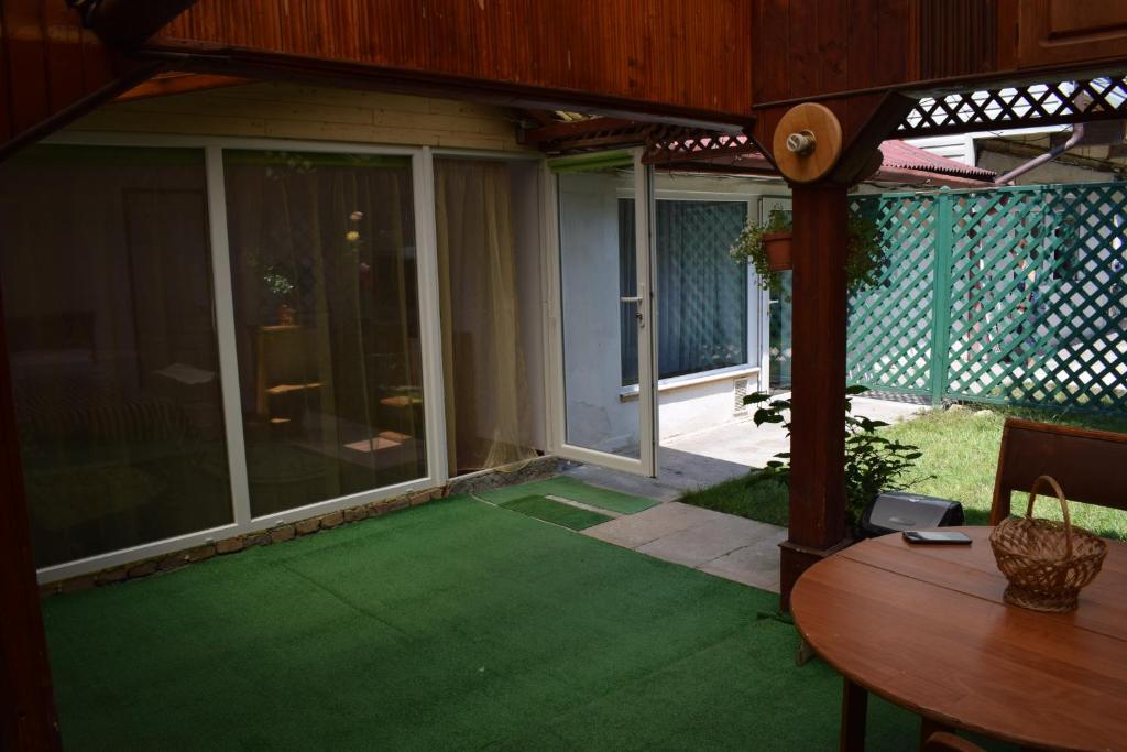 an enclosed patio with a green lawn with a table at Cluj Center 2 in Cluj-Napoca