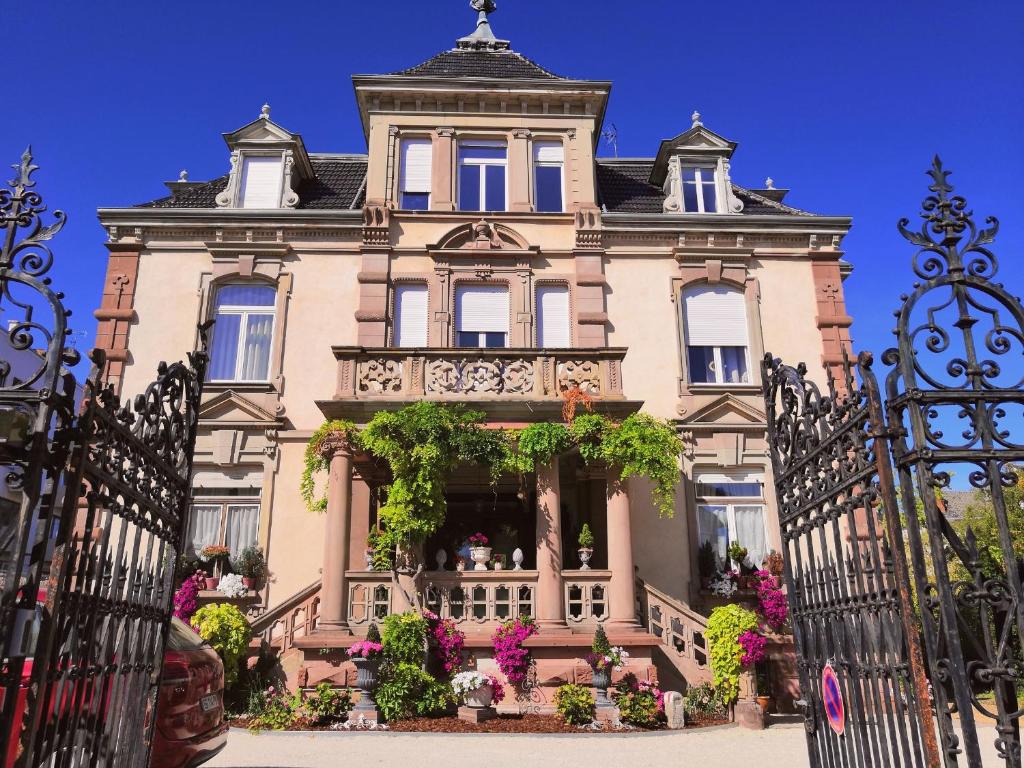 uma casa grande com um portão em frente em Castelnau em Colmar