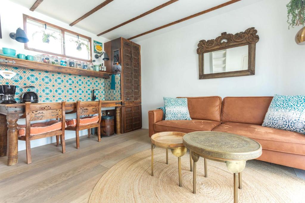 ein Wohnzimmer mit einem Sofa und einem Tisch in der Unterkunft House boat studio with waterfront terrace in Amsterdam