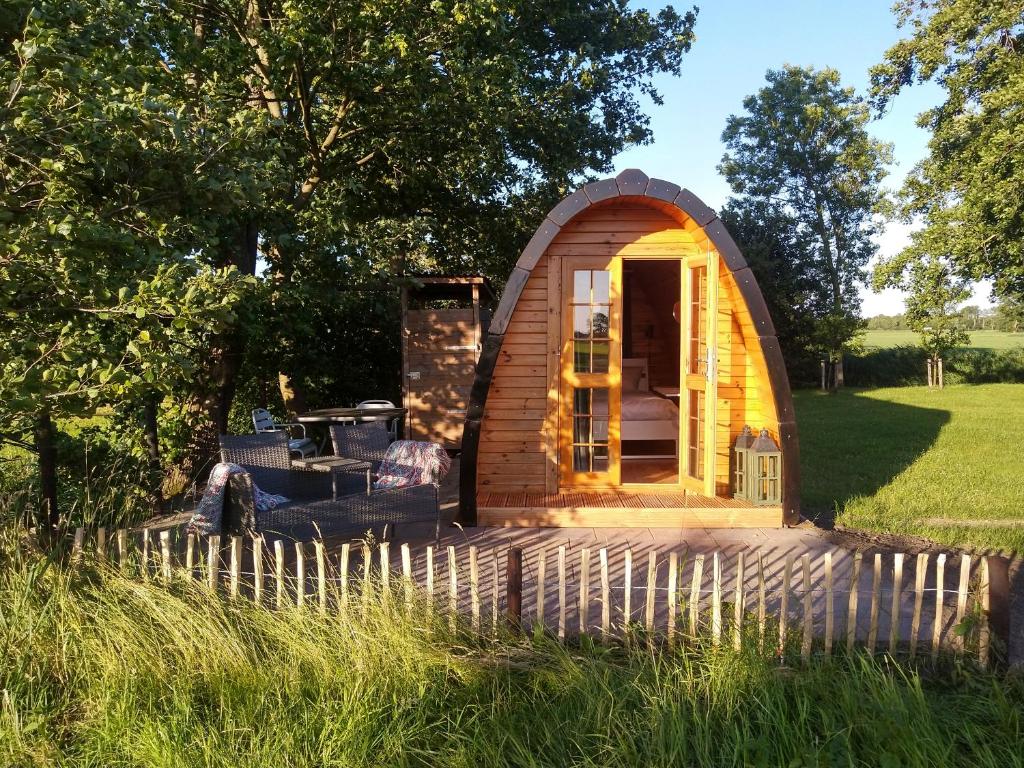 uma pequena cabana de madeira no meio de um campo em Weids Zicht BB Weidszicht em Doezum