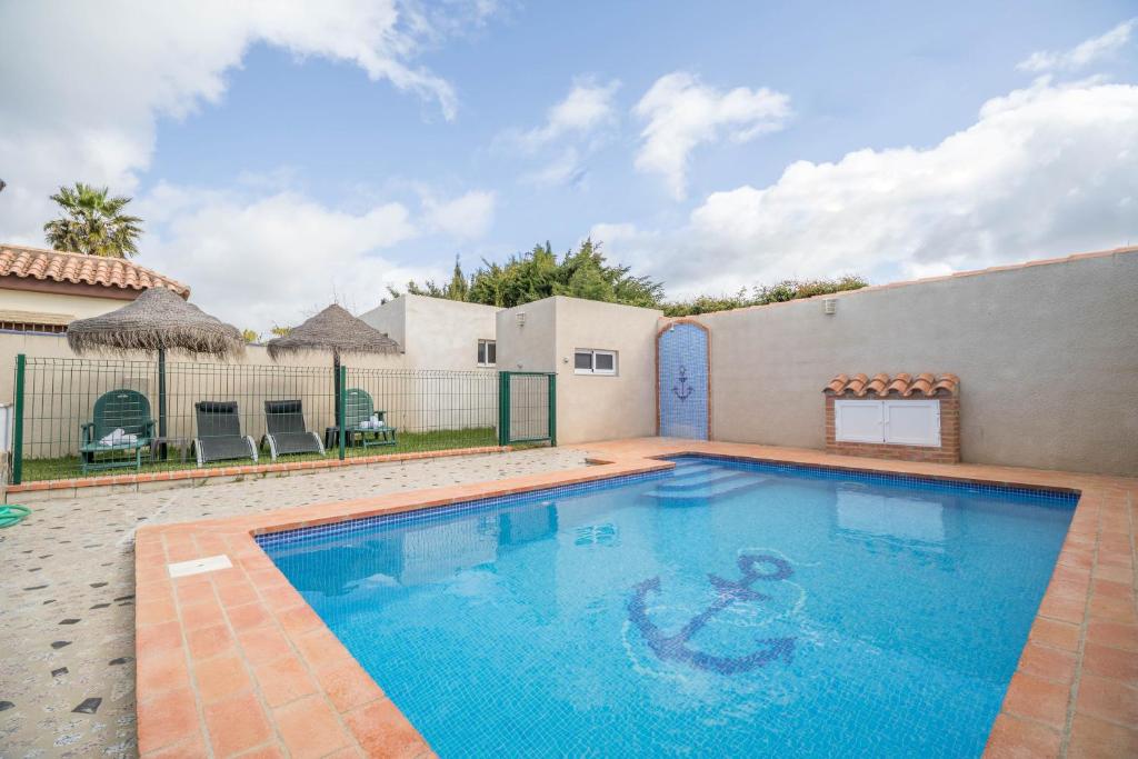a swimming pool in the backyard of a house at Casa Rural La Ermita in Conil de la Frontera