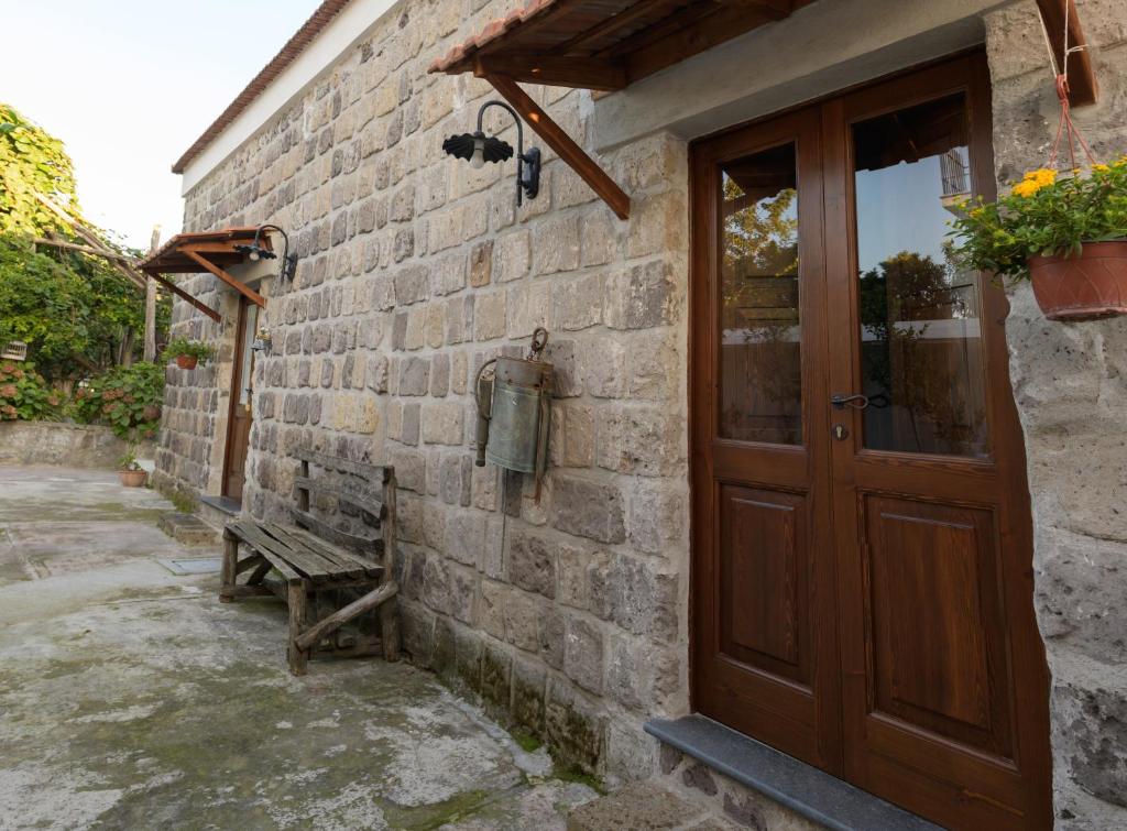 un edificio in mattoni con una porta in legno e una panca di Emy's Country House a Castellammare di Stabia