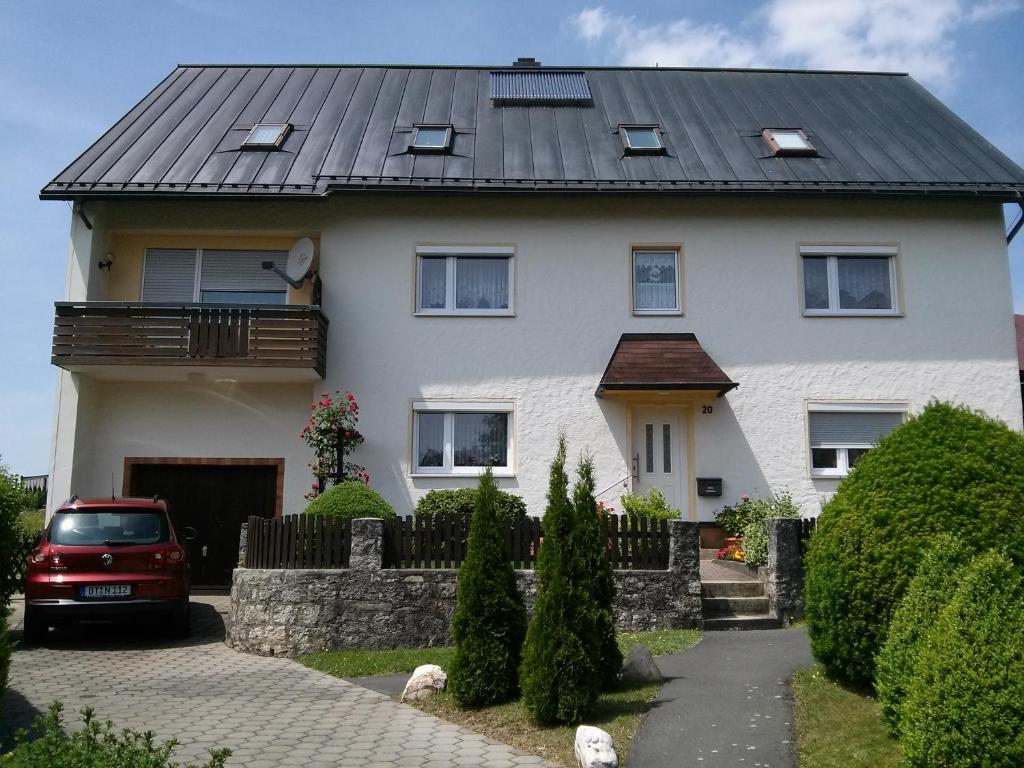 a white house with a black roof at Ferienwohnung Heike Greiner in Bischofsgrün