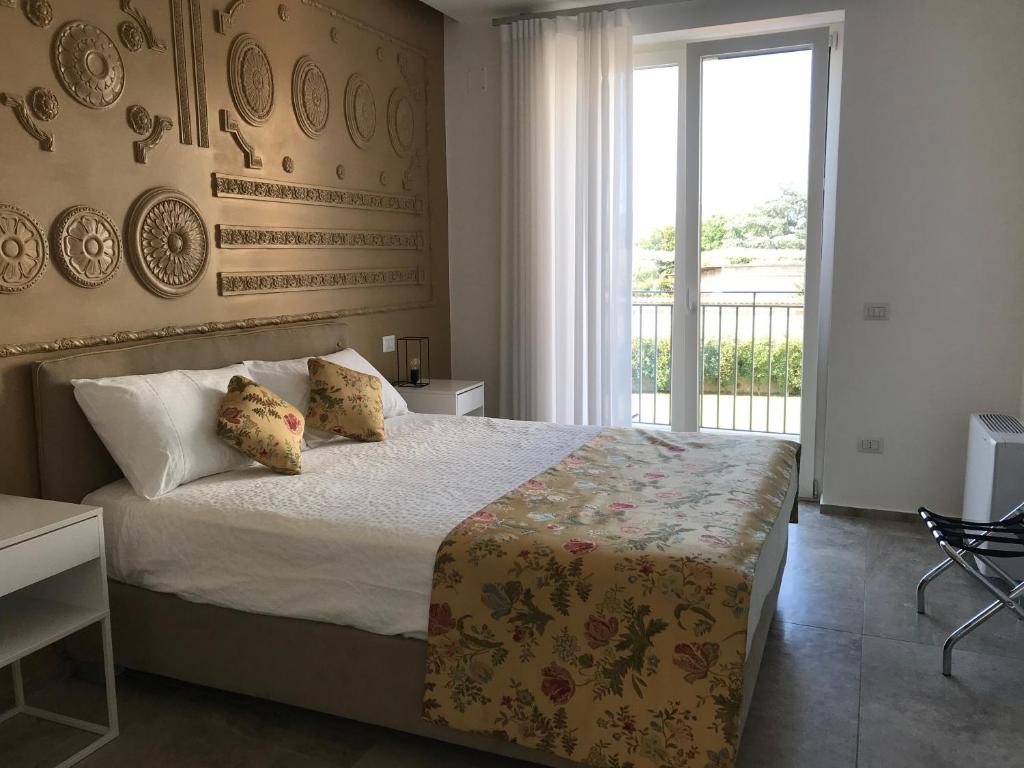 um quarto com uma cama e uma grande janela em Il Cavaliere Bed and Breakfast em Caserta