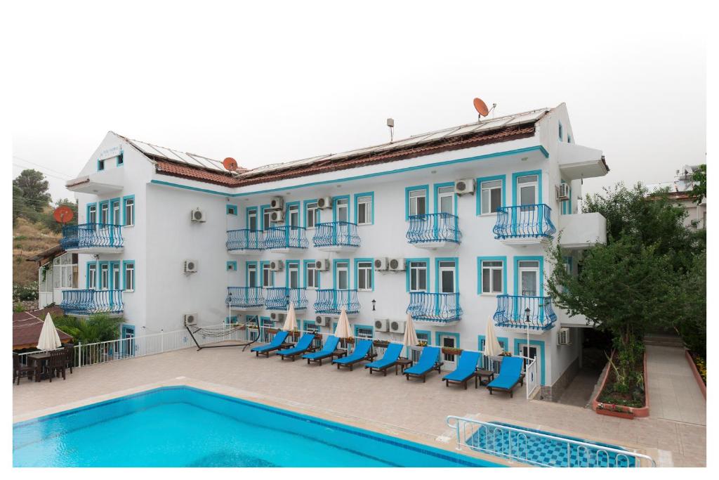 een groot gebouw met een zwembad ervoor bij Mavi Yaprak Hotel in Oludeniz
