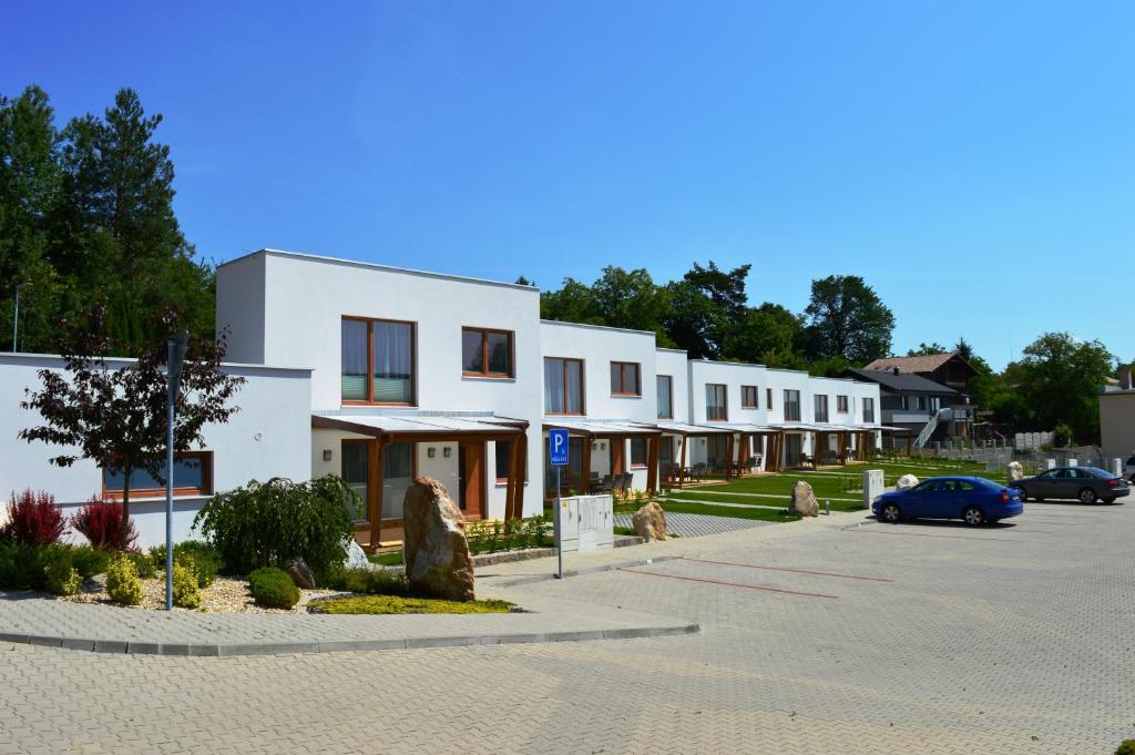 Poruba的住宿－Bojnice Krásna Poruba，停车场内一排有汽车的房屋