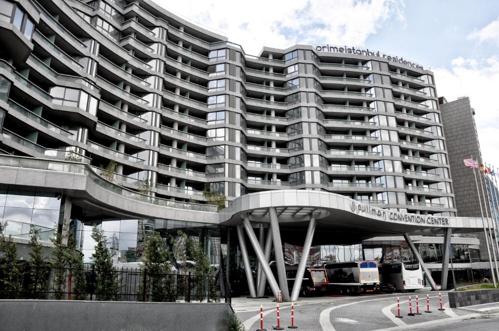 duży budynek apartamentowy z zakrzywioną fasadą w obiekcie Prime Istanbul Residences w Stambule