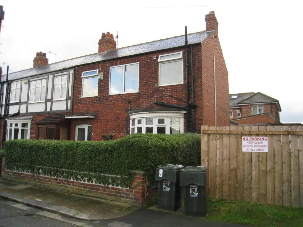 a brick house with two trash cans in front of it at Eastgate Road in Middlesbrough