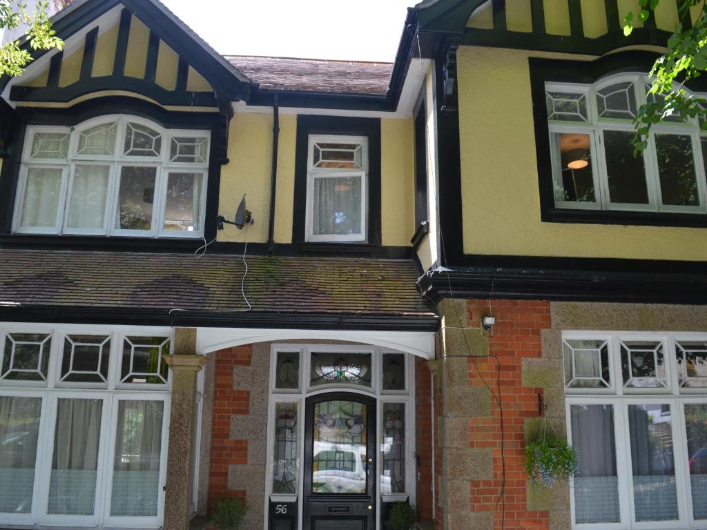 una casa amarilla y negra con una puerta en Owl House en Redruth