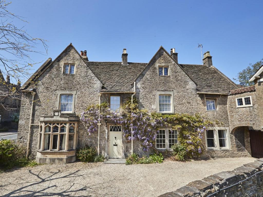 uma antiga casa de pedra com uma porta branca em Rook Lane House em Frome