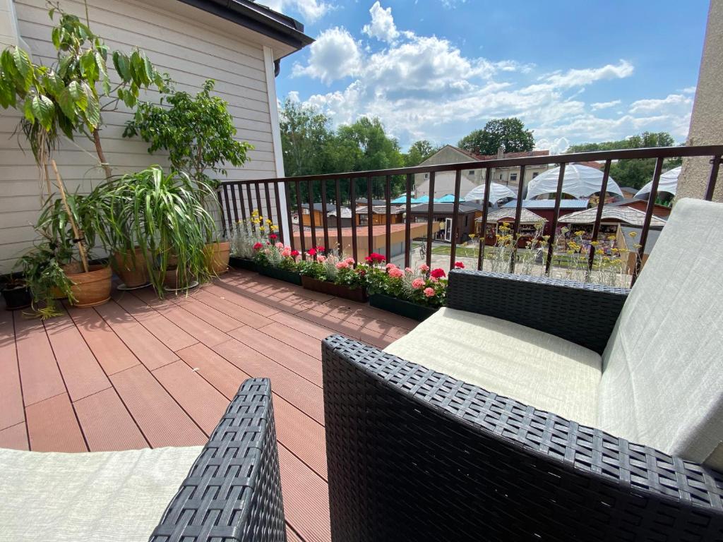 a patio with a couch and a chair on a balcony at Apartamentai Eurista in Druskininkai