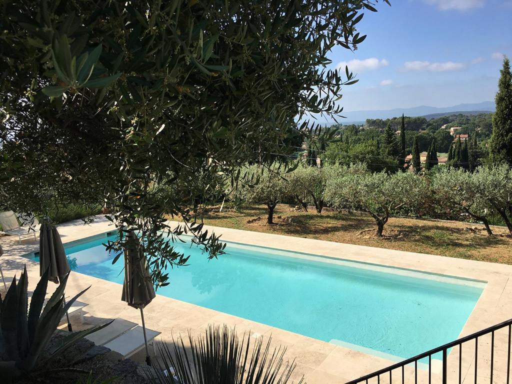 una piscina en una villa con olivos en LE NOMADE au Clos en Provence, en Flayosc