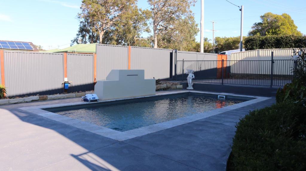 una piscina con una boca de incendios en un patio trasero en La Nest Private Studio, en Gorokan