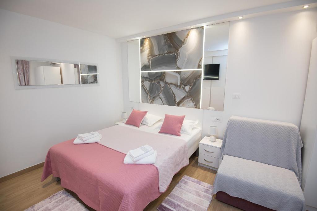 1 dormitorio con 2 camas con sábanas rosas y espejo en Luxury Studio Apartment Honeymoon, en Split