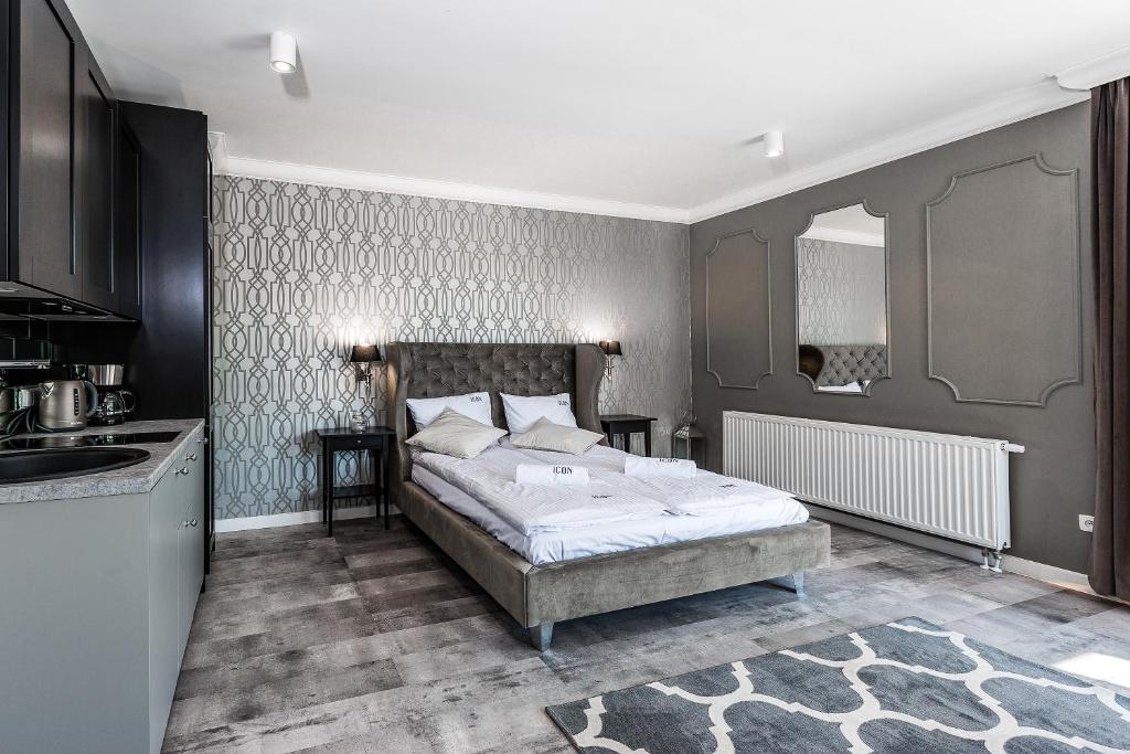 a bedroom with a bed and a kitchen in it at ICON APARTMENTS in Gdańsk