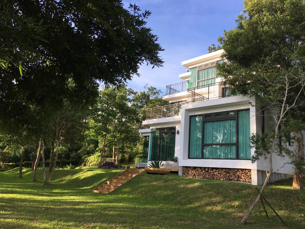 a house with green windows and a yard at Greenville Maioli in Tongxiao