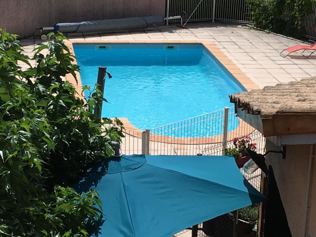 a swimming pool with a blue tarp in a yard at Résidence Le Grand Virage in Pont-de-Labeaume