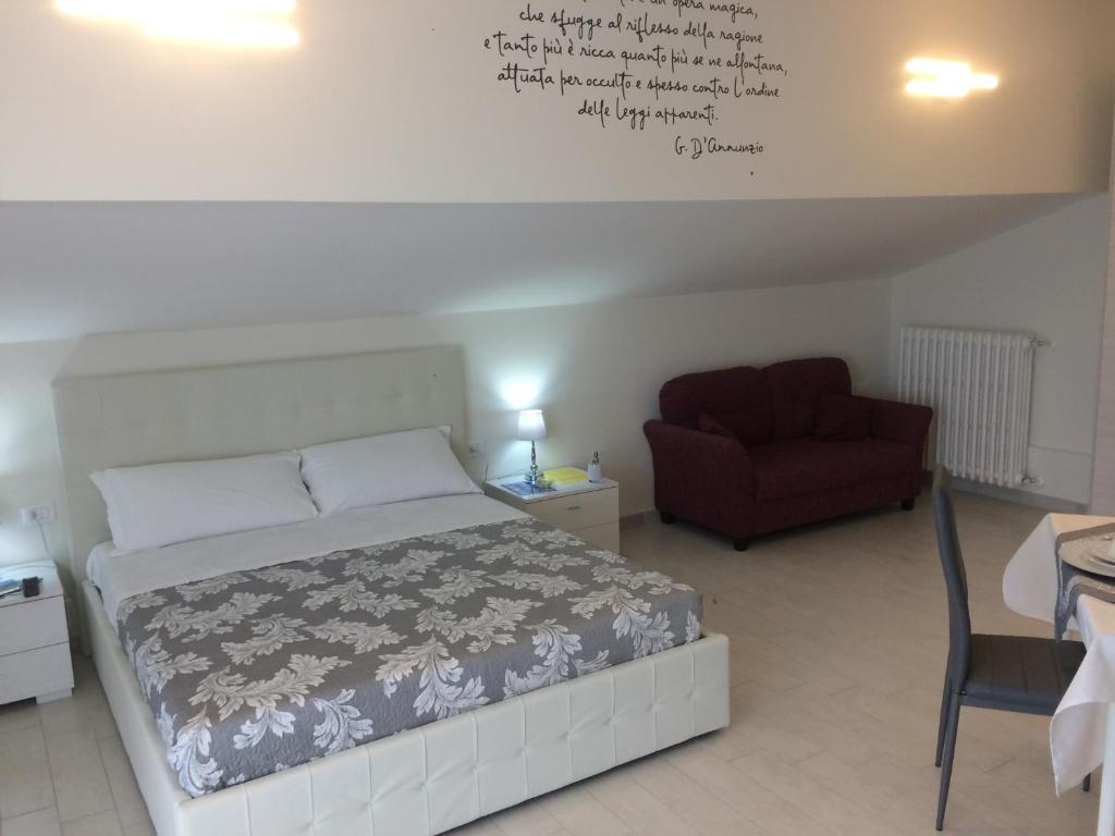 1 dormitorio con 1 cama y 1 silla roja en Terrazze Dannunziane en Pescara
