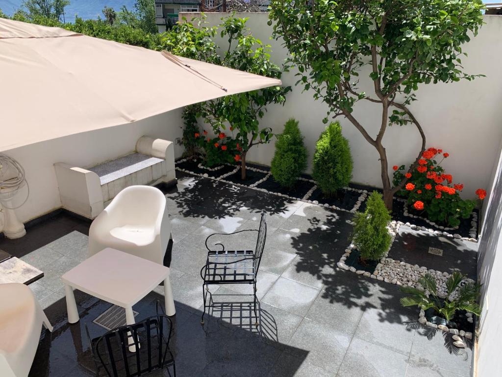 een patio met een tafel en stoelen en een boom bij Lemon Tree in Torre Annunziata