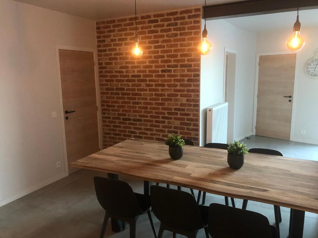 a dining room with a wooden table and chairs at 't schotje in Ledegem