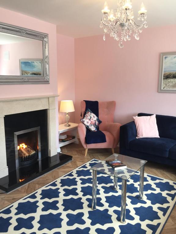 a living room with a couch and a fireplace at St Anthony's Rosslare Strand in Mervyn