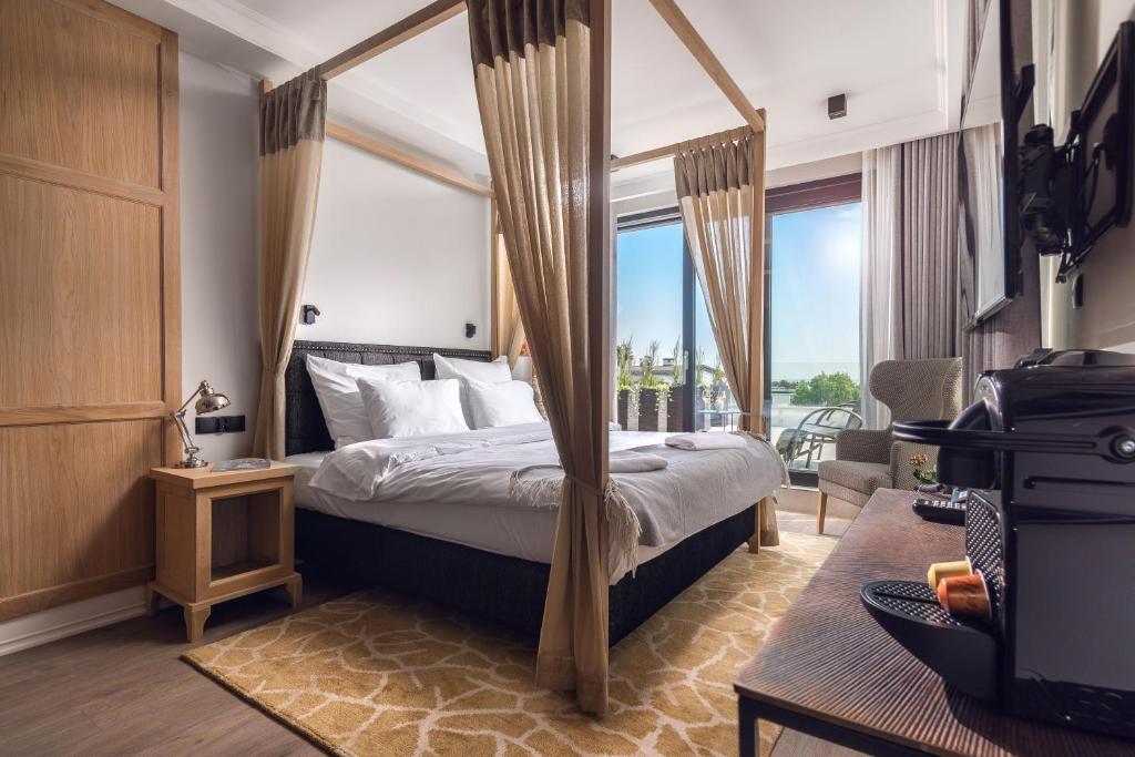 ein Schlafzimmer mit Himmelbett und großem Fenster in der Unterkunft Moje Orłowo Boutique Bed & Breakfast - Adults Only in Gdynia