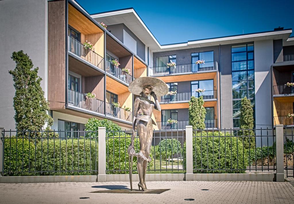 uma estátua de uma mulher segurando um guarda-chuva em Turaidas Kvartāls em Jūrmala