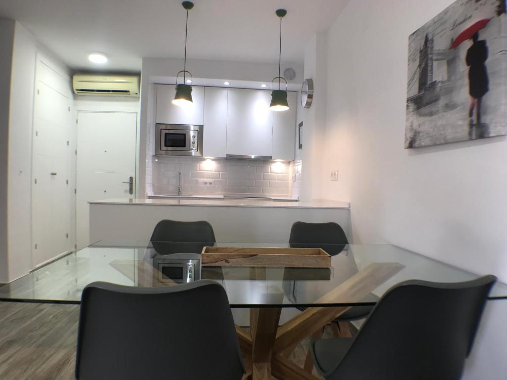 a dining room with a glass table and chairs at Apartmento Apartaclub La Barrosa 223 in Chiclana de la Frontera