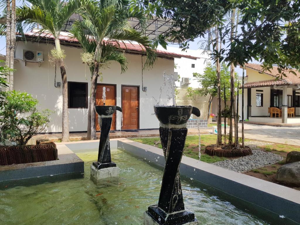 a water fountain in front of a house at Villetta House Syariah in Kudus