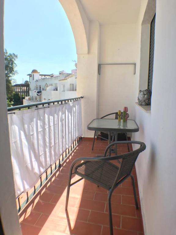 a balcony with a table and chair on a balcony at Apartmento Apartaclub La Barrosa 223 in Chiclana de la Frontera