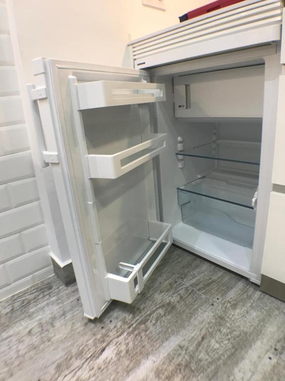 an empty refrigerator with its door open in a room at Apartmento Apartaclub La Barrosa 223 in Chiclana de la Frontera