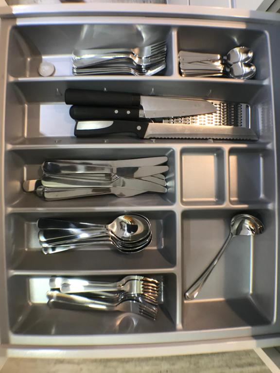 a metal drawer filled with silver utensils at Apartmento Apartaclub La Barrosa 223 in Chiclana de la Frontera