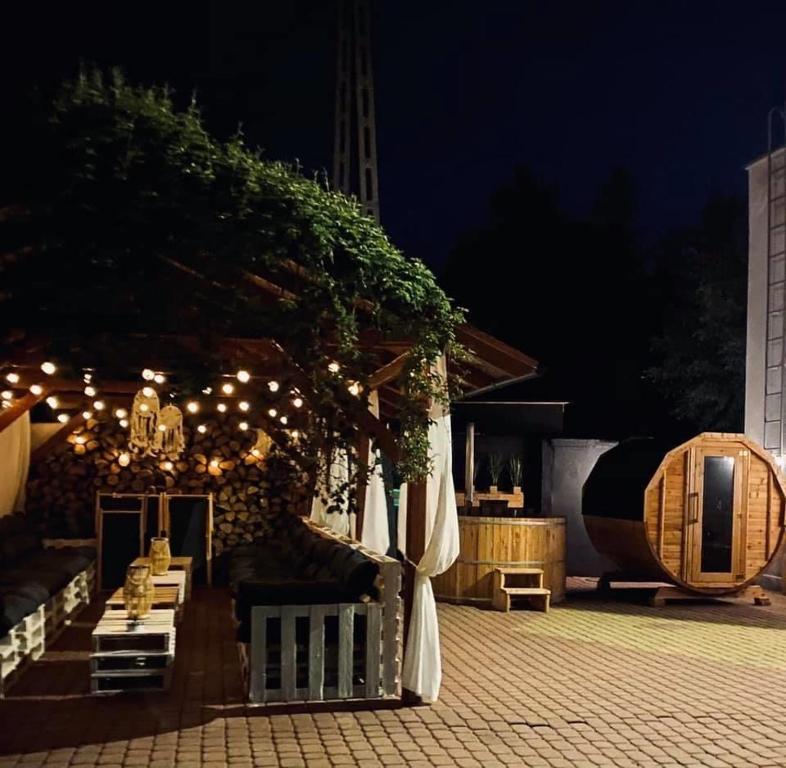 a patio with a table and a pavilion at night at Jantarowy Sen in Jantar