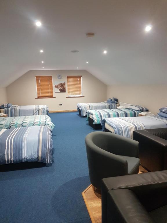 a room with rows of beds in a classroom at Reubens Loft in Bushmills
