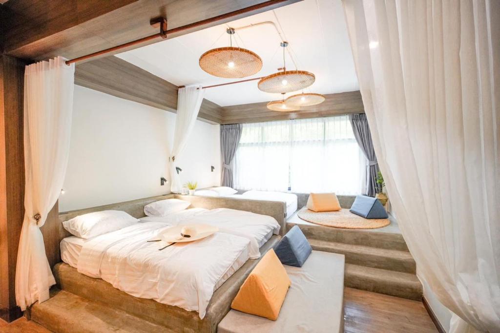 a bedroom with two beds and a window at Krung Boutique Hotel in Bangkok