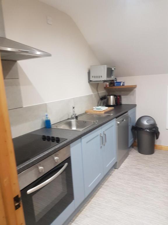 a small kitchen with a sink and a stove at Reubens Loft for 1 to 6 person Family 4 miles outside Portrush in Bushmills