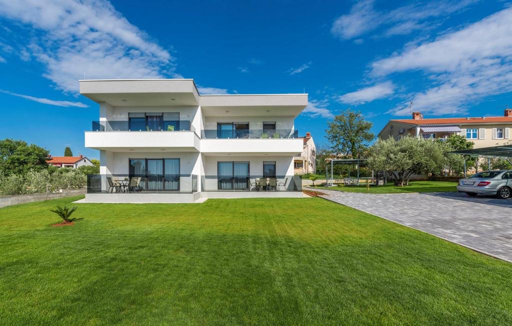 a large white house with a green yard at Apart Residence Blue Sea in Poreč