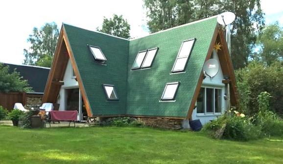 Matilda I-die außergewöhnliche Finnhütte في Ahrensberg: منزل أخضر مع سقف أخضر على ساحة
