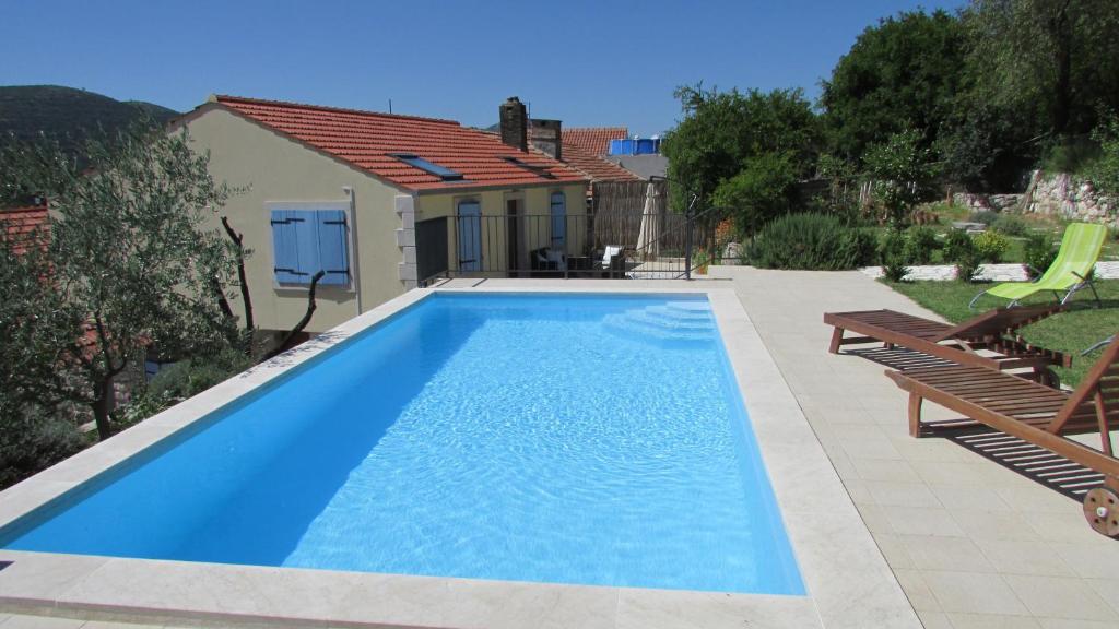 a swimming pool in the backyard of a house at Holiday Home Stari Zoganj in Potomje