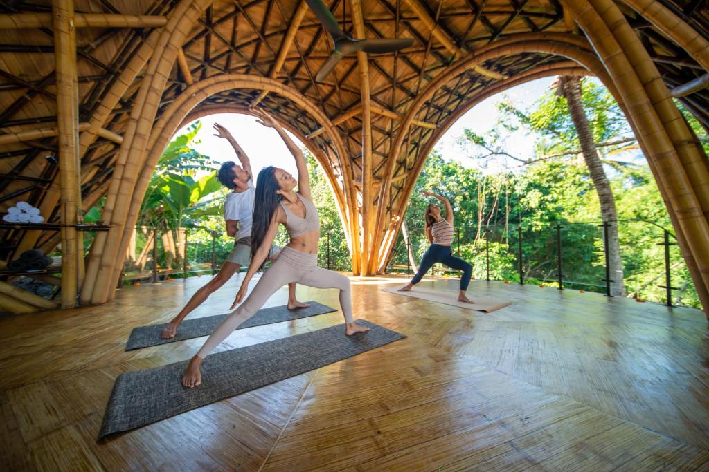 un gruppo di persone che fanno yoga in una stanza di Ulaman Eco Luxury Resort a Tabanan