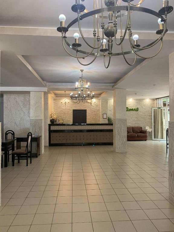 a lobby with a chandelier and a living room at Pensiunea Doneli in Eforie Nord