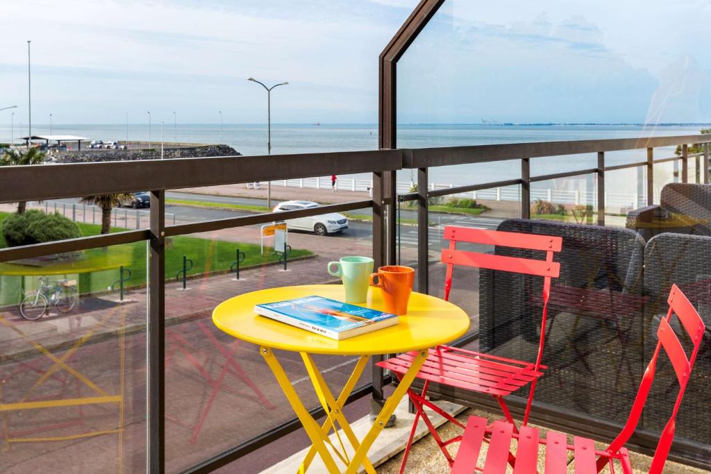 a table and chairs on a balcony with a view of the beach at Best Western Hôtel Royan Océan in Royan