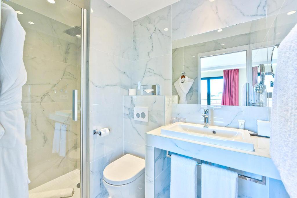 a bathroom with a sink and a toilet and a shower at Hôtel La Villa Port d'Antibes & Spa in Antibes