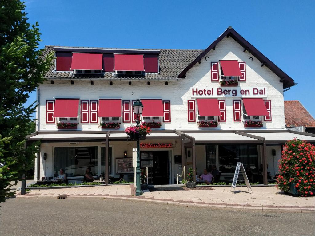 un edificio rojo y blanco con un cartel en él en Hotel Berg en Dal, en Epen