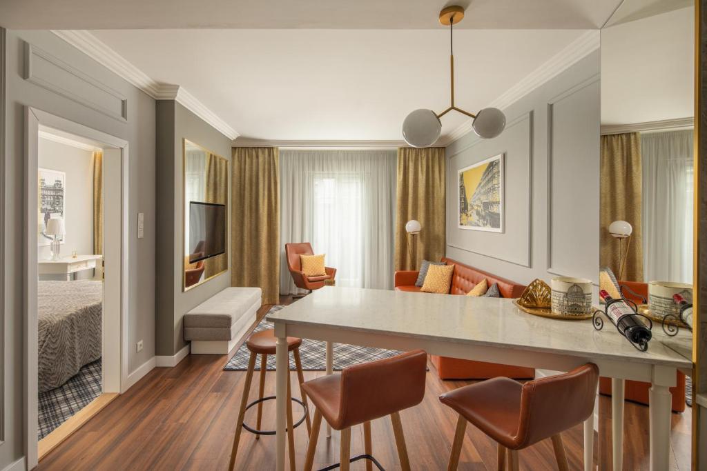 uma sala de estar com uma cama e uma sala de jantar em Mamaison Residence Izabella Budapest em Budapeste